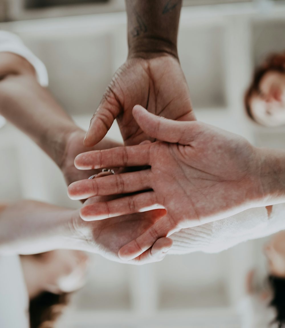 Hands joined together in a team huddle